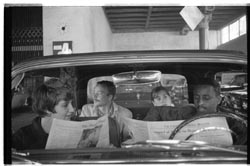 People in car reading newspapers